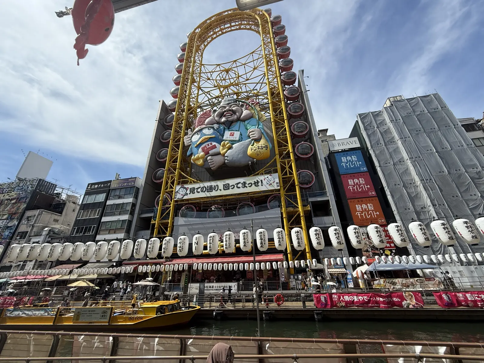 The oval Ebisu Tower ferris wheel mounted on the Don Quijote building over the Dotonbori canal in Osaka