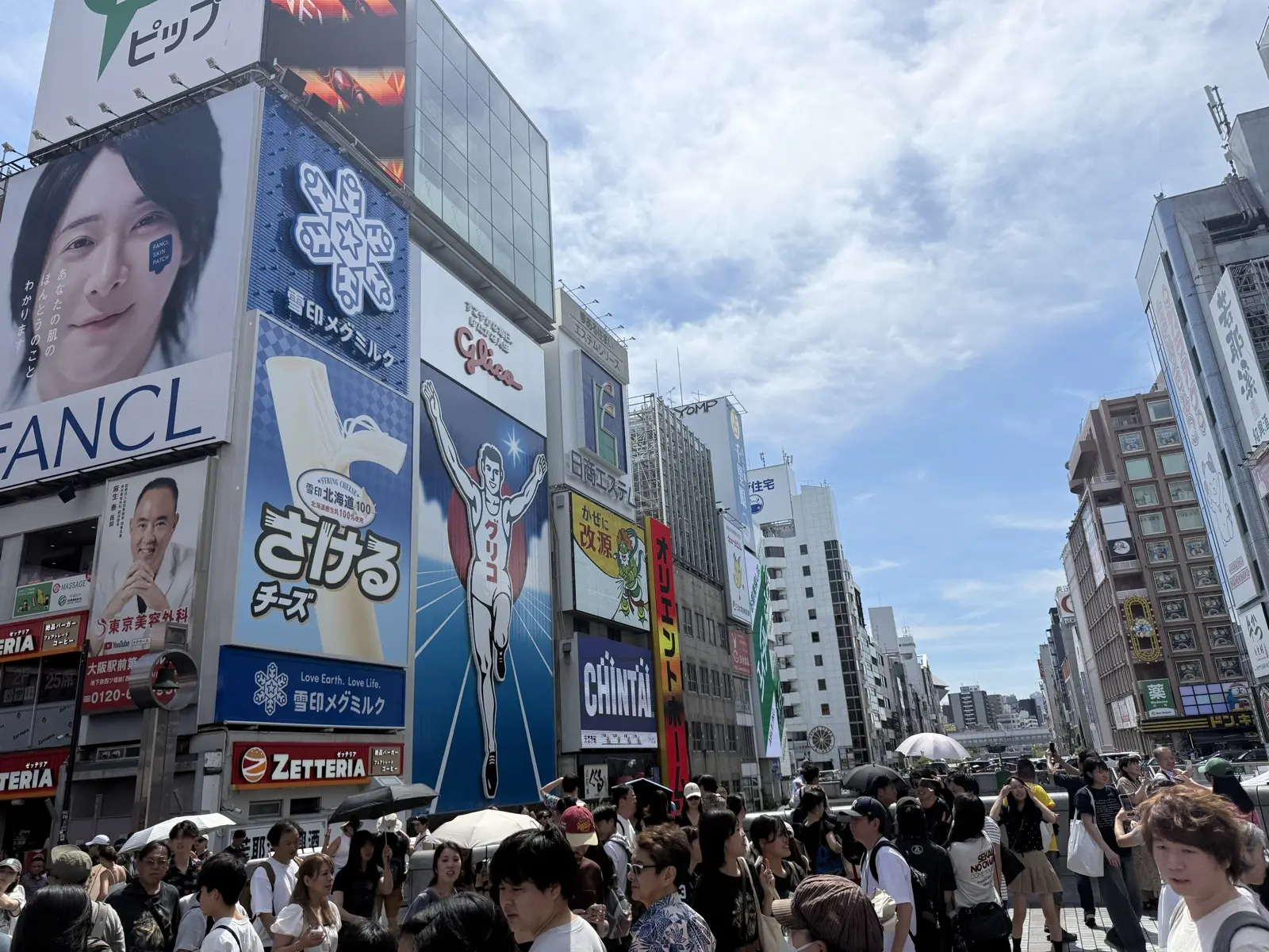 The Glico running-man sign glowing over the Dotonbori canal in Osaka at the Ebisubashi bridge