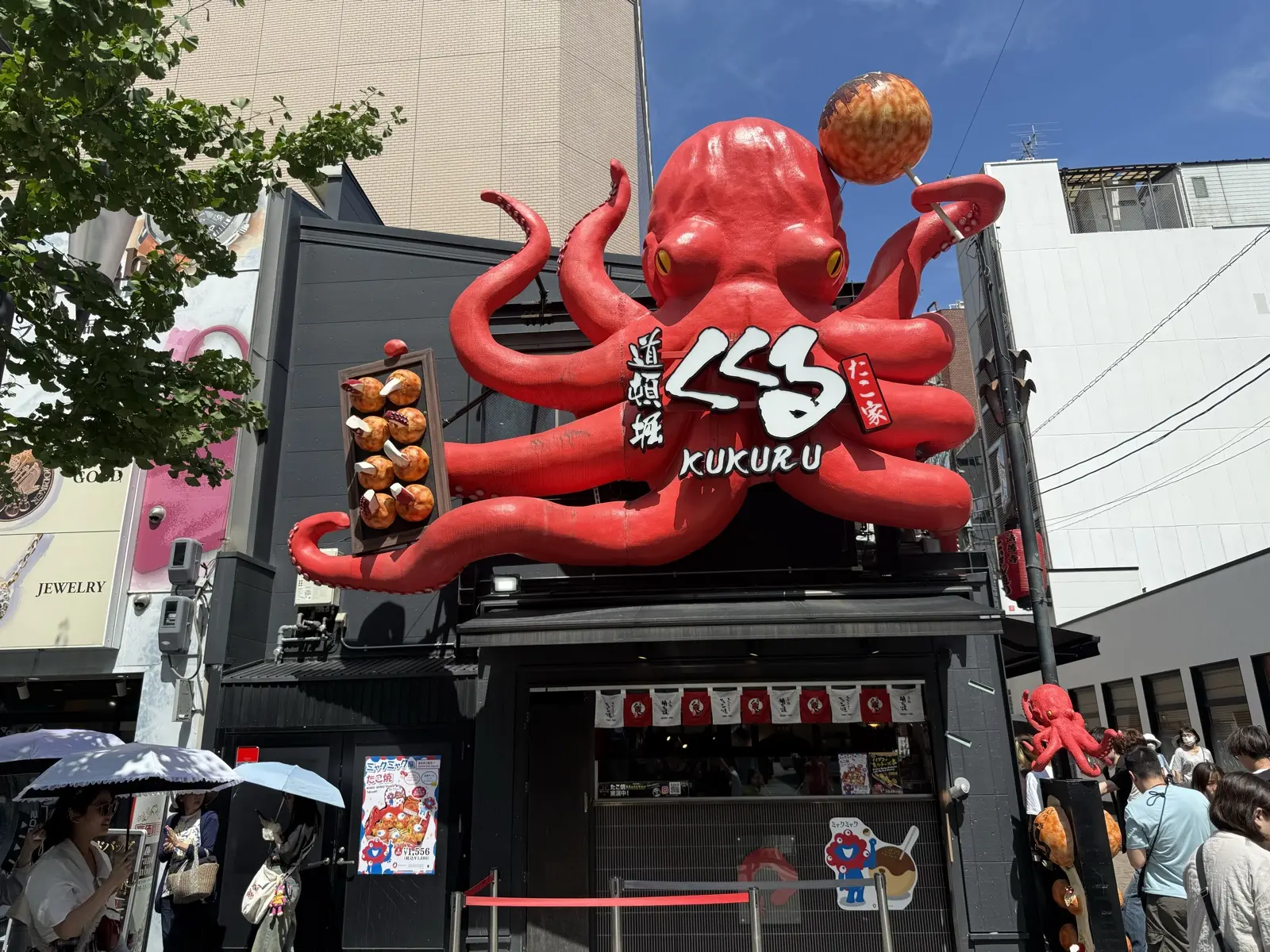 The giant red octopus sculpture grabbing the Takoyaki Kukuru building in Dotonbori, Osaka