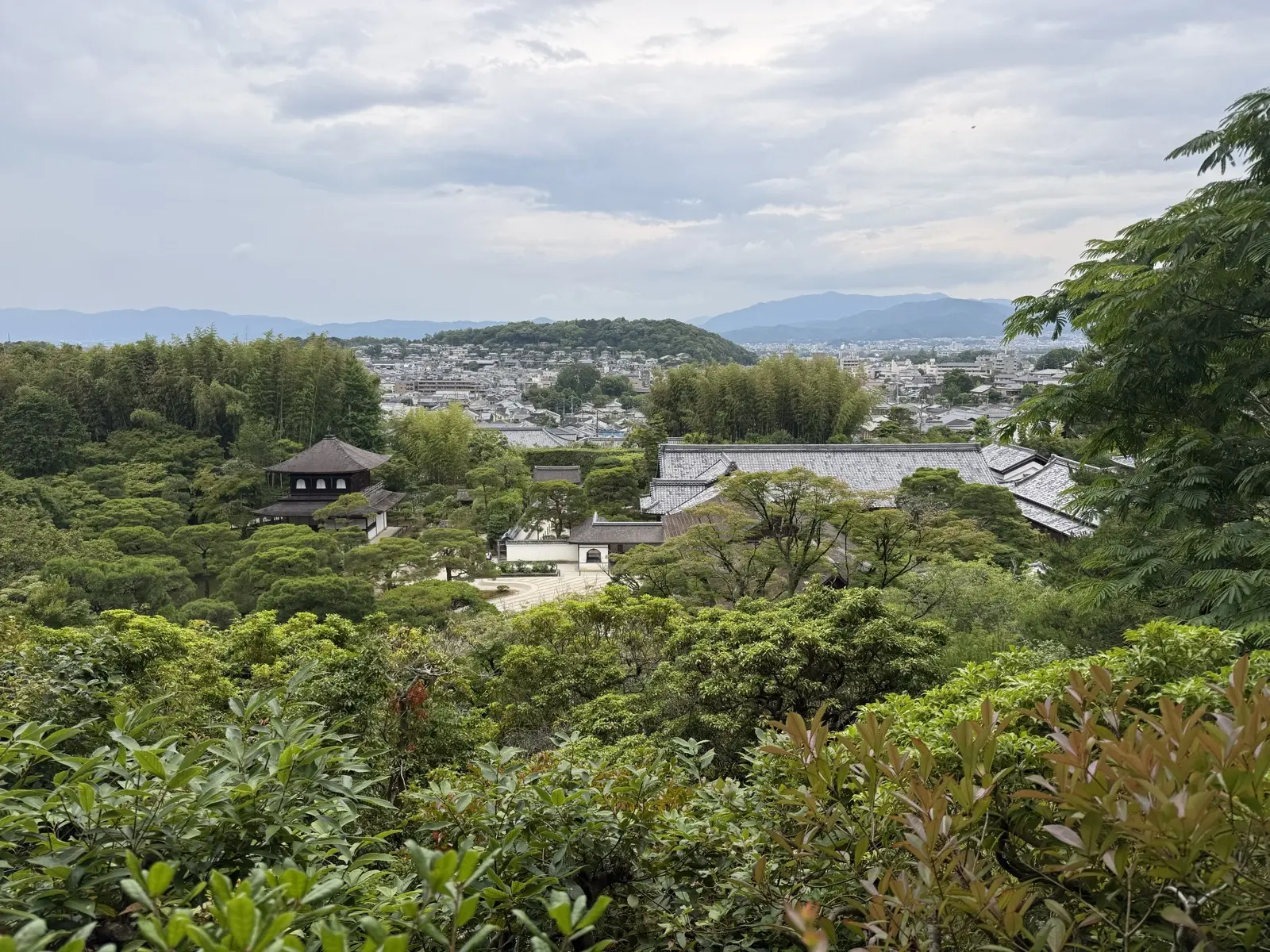 View from the hillside path at Ginkaku-ji over the temple roofs and across Kyoto — our own photo