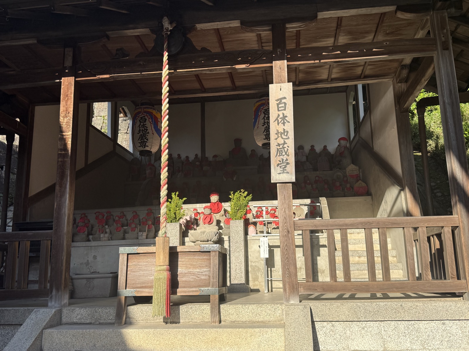 The Hyakutai Jizo hall at Kiyomizu-dera, rows of small stone Jizo statues in red bibs — our own photo