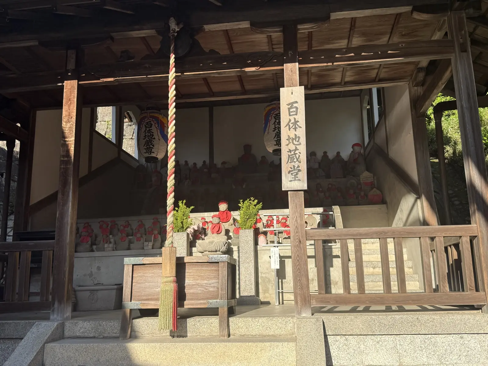 The Hyakutai Jizo hall at Kiyomizu-dera, rows of small stone Jizo statues in red bibs — our own photo