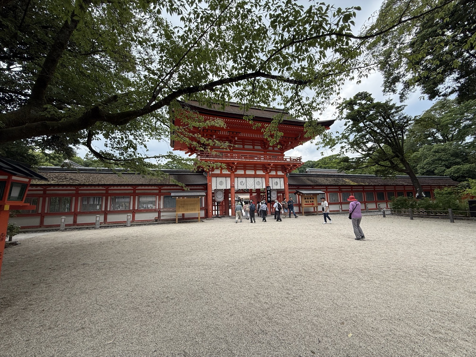 The vermilion Romon gate of Shimogamo Shrine framed by trees in Kyoto — our own photo