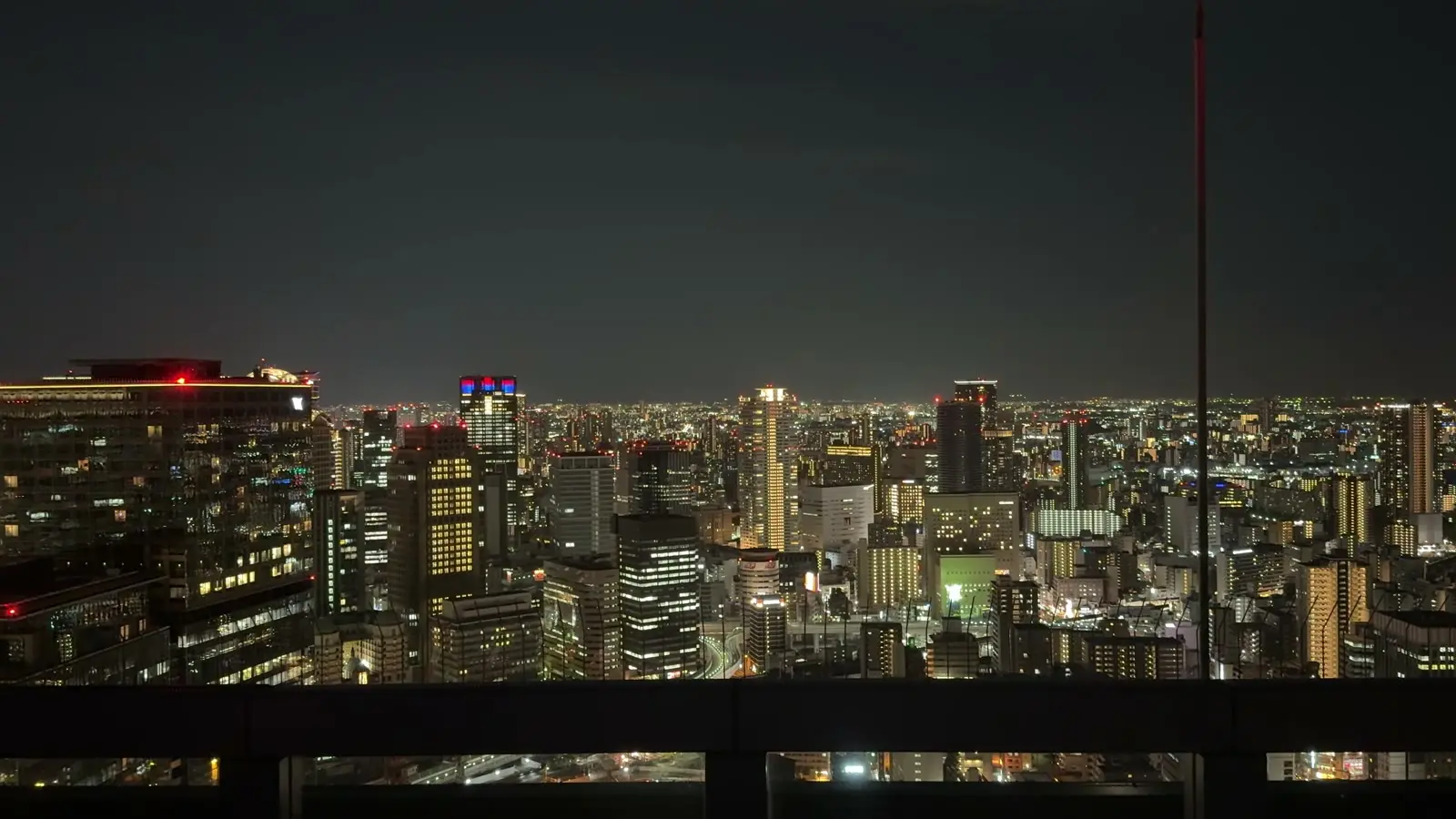 Osaka's night skyline lit up, seen from the open-air Floating Garden Observatory at the Umeda Sky Building