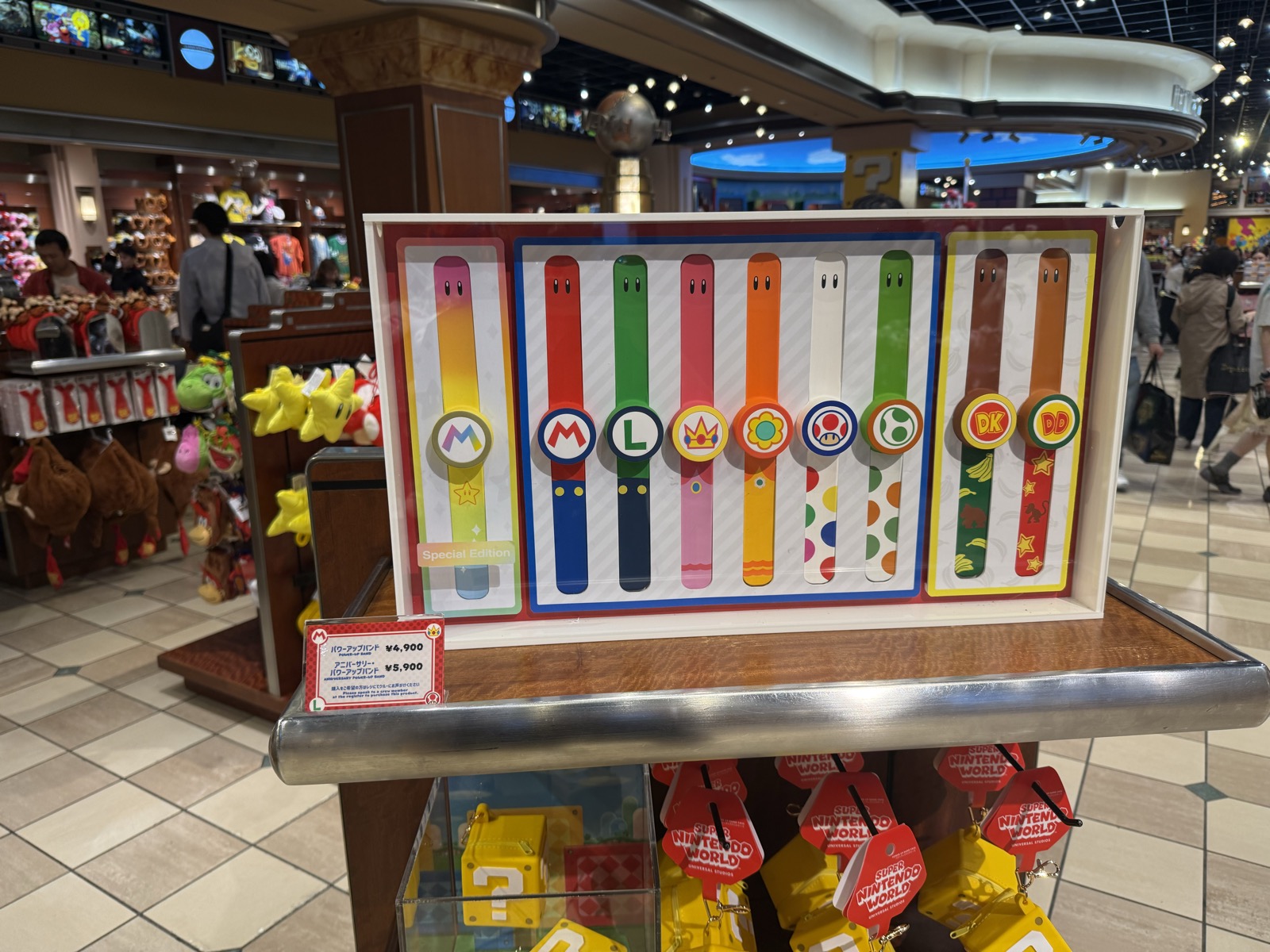Power-Up Bands on sale in the Super Nintendo World store, one design per character, priced around ¥5,900 — our own photo