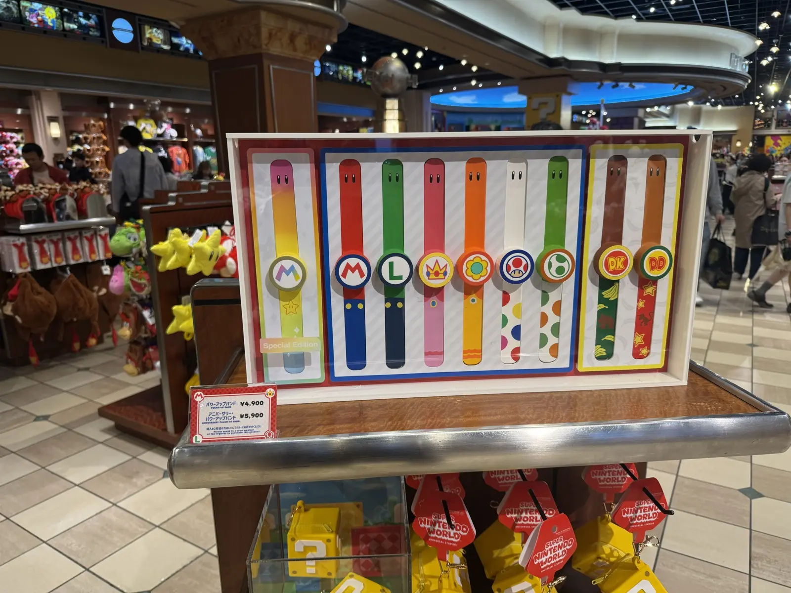 Power-Up Bands on sale in the Super Nintendo World store, one design per character, priced around ¥5,900 — our own photo